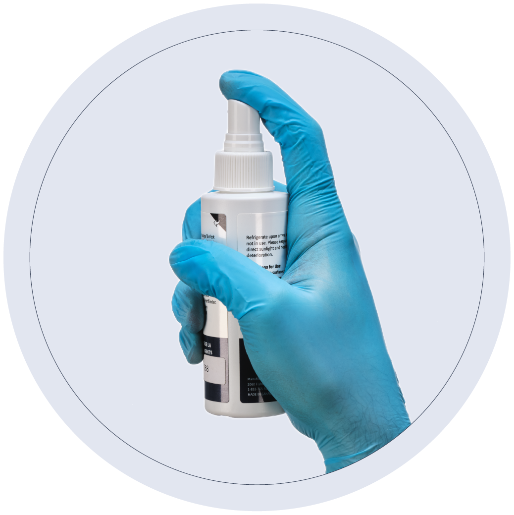 Finger putting pressure on Optisolve Illuminator spray