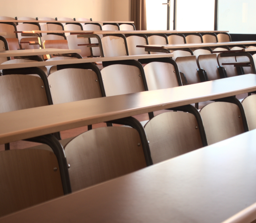 Large university classroom with rows of chairs and desks